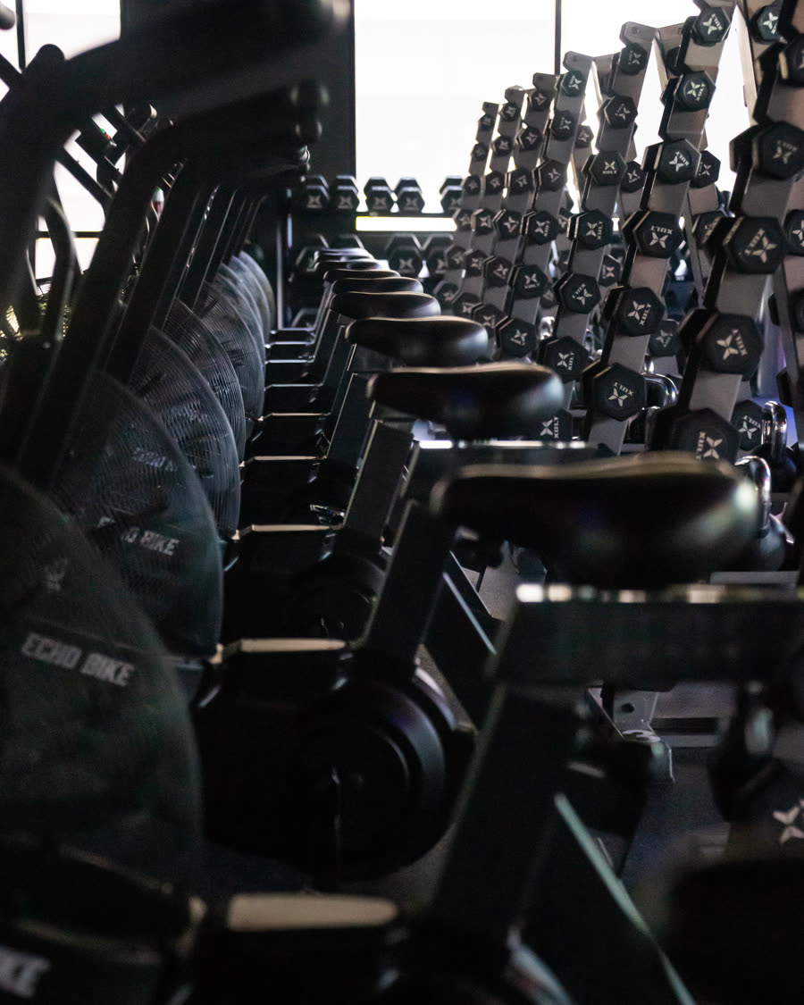 Echo bikes and racked dumbbells on the Bria Method floor