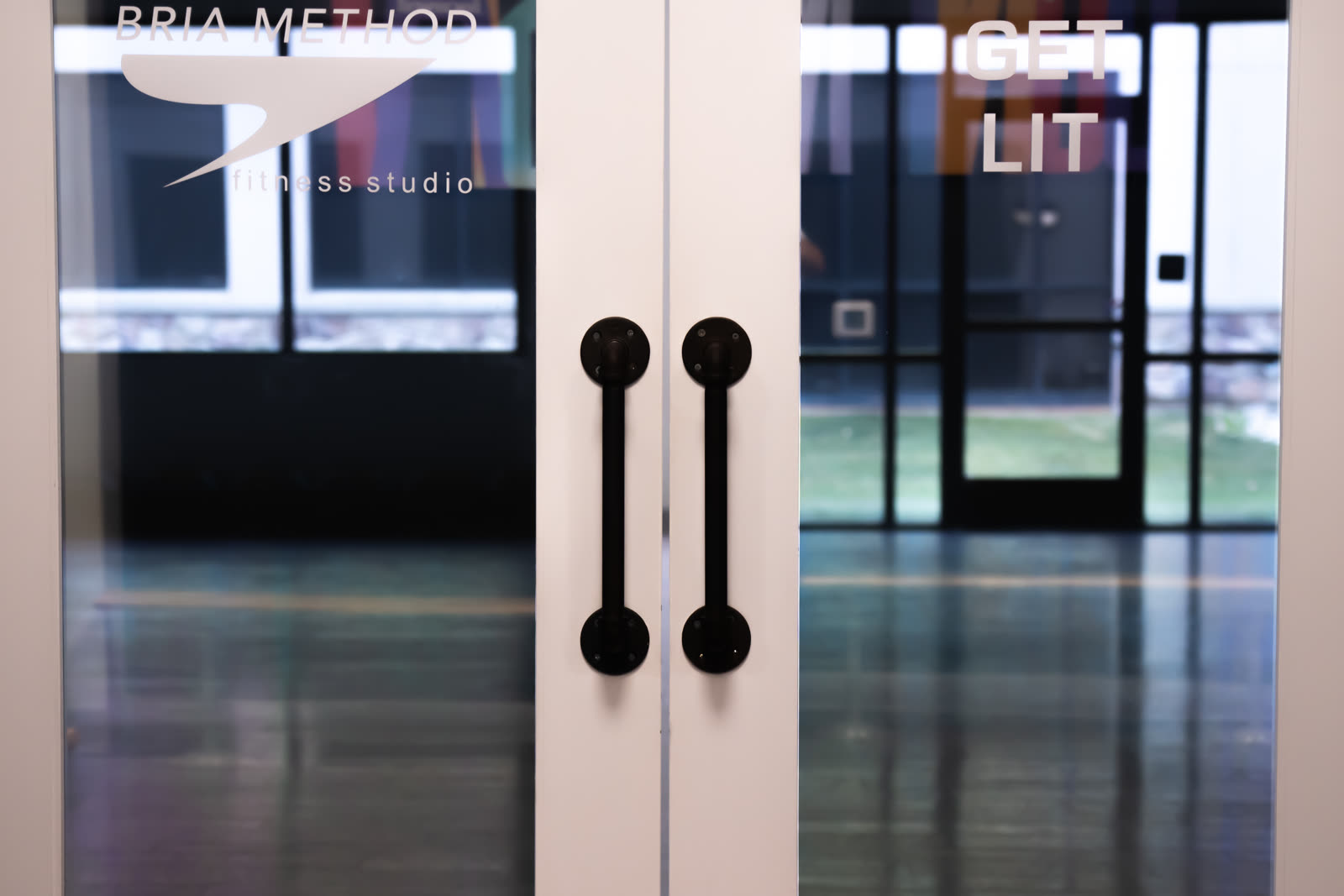 The Bria Method front doors, with the studio floor visible through the glass