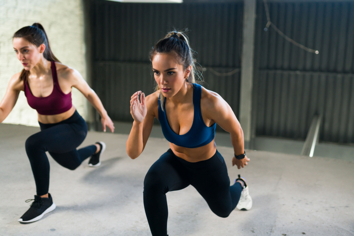 Two women running through a HIIT workout